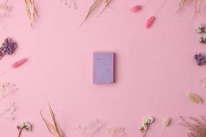 Soap and flower on pink background. Flat lay, copy space. photo