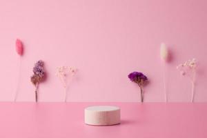 Cosmetic background with wooden podium and flowers on pink. Empty showcase for cosmetic product presentation. photo