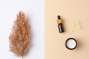 composición mínima con productos cosméticos para el cuidado de la piel y pampas sobre fondo beige pastel. endecha plana foto