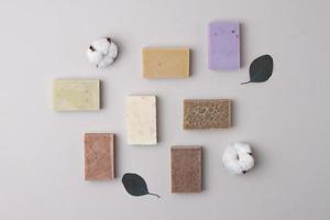 Soap with flowers on pastel grey background. Flat lay, copy space. photo