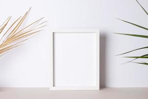 Home decoration with white mock up frame and palm leaf on grey. Artwork showcase. Close up, copy space photo