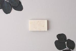 Soap and flower on grey background. Flat lay, copy space. photo