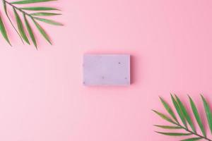 Soap with palm on pink background. Flat lay, copy space. photo