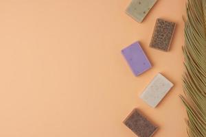 Soap and palm on beige background. Flat lay, copy space. photo