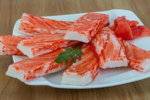 Crab sticks on the plate and wooden background photo