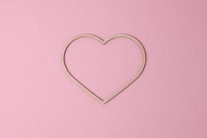 Cosmetic background with a wooden heart on pink. Flat lay, copy space photo