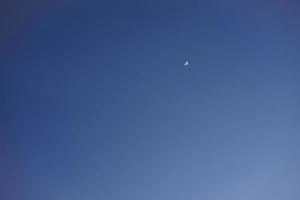 Crescent moon with empty blue sky copy space for banner or wallpaper background photo