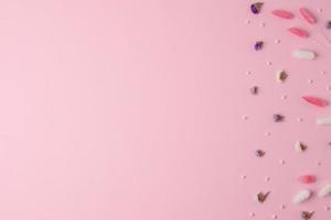 Cosmetic background with flowers on pink. Flat lay, copy space photo