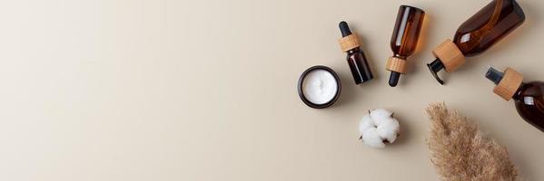 productos cosméticos para el cuidado de la piel con pampa sobre fondo beige pastel. endecha plana, espacio de copia foto
