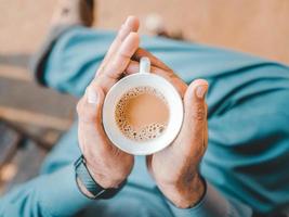 A man holding a warm chai tea photo