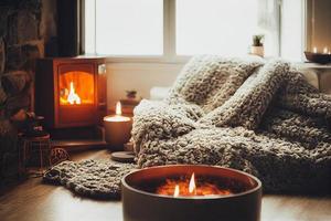 Cozy winter or autumn morning at home. Hot coffee with gold metallic spoon, warm blanket, garland and candle lights, swedish hygge concept photo