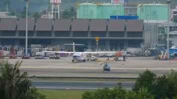 phuket, tailândia 1 de dezembro de 2016 - manutenção técnica e de serviço de aeronaves das vias aéreas de bangkok, terminal do aeroporto de phuket. helicóptero no aeródromo. vista panorâmica do pátio do aeroporto video