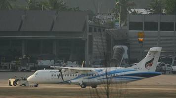 phuket, tailândia, 4 de dezembro de 2016 - bangkok airways atr 72 hs pza rebocando antes da partida, de manhã cedo. vista do último andar do hotel centara grand west sands resort phuket video