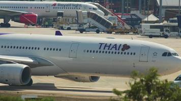 Phuket, Tailandia 25 de noviembre de 2016 - thai airways airbus a330 hs teu y thai airasia airbus a320 hs abc rodando antes de la salida del aeropuerto de phuket. video