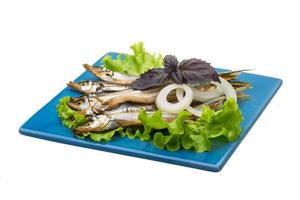 Dried Capelin on the plate and white background photo
