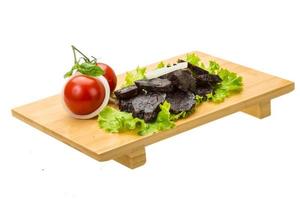 Horse sausages on wooden board and white background photo