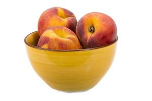 Peaches in a bowl on white background photo