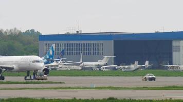ALMATY, KAZAKHSTAN MAY 4, 2019 - Boeing 757 of Air Astana pulls a tractor at Almaty International airport. The passenger plane is preparing to take off. Tourism and travel concept video
