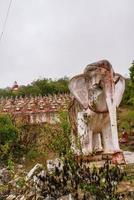 escultura de elefante en el antiguo templo con numerosas imágenes antiguas de buda en la montaña en mingun, región de sagaing, myanmar foto