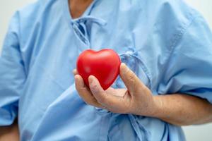 Asian senior or elderly old lady woman patient holding red heart, healthy strong medical concept. photo