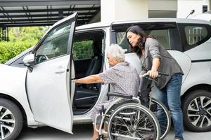 Help and support asian senior or elderly old lady woman patient prepare get to her car. photo