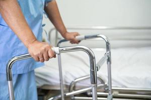 Asian lady woman patient walk with walker at nursing hospital ward, healthy strong medical concept photo