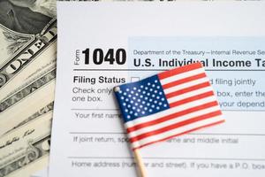 Tax Return form 1040 with USA America flag and dollar banknote, U.S. Individual Income. photo