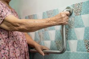 Asian senior or elderly old lady woman patient use toilet bathroom handle security in nursing hospital ward, healthy strong medical concept. photo