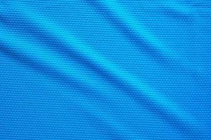 Blue football jersey clothing fabric texture sports wear background, close up top view photo