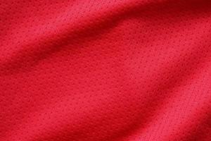 Red sports clothing fabric football shirt jersey texture close up photo