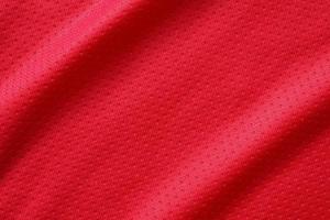 Red sports clothing fabric football shirt jersey texture close up photo