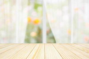 mesa de madera vacía con ventana de cortina blanca borrosa y fondo de jardín verde para la plantilla de exhibición de productos foto