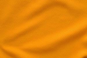 vista superior de textura de camiseta de fútbol de jersey de tela de ropa deportiva de color naranja foto