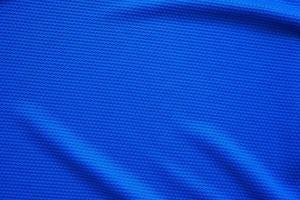 Blue football jersey clothing fabric texture sports wear background, close up top view photo