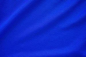 Blue football jersey clothing fabric texture sports wear background, close up top view photo