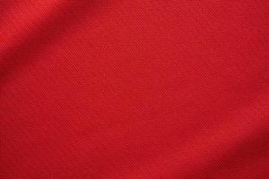 Red sports clothing fabric football jersey texture close up photo