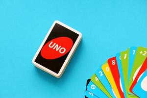 TERNOPIL, UKRAINE - MAY 15, 2022 Many colorful UNO game cards on blue background. UNO is an American shedding-type card game that is played with a specially printed deck photo