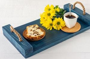 Slices of pound cake with raisins and a cup of coffee served on a tray. Morning tasty breakfast photo