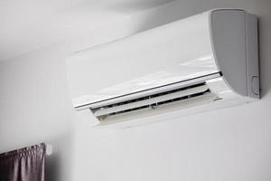 Air conditioner on white wall room interior background photo