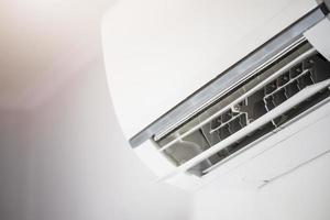 Air conditioner on white wall room interior background photo