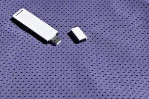 A modern portable USB wi-fi adapter is placed on the violet sportswear made of polyester nylon fiber photo