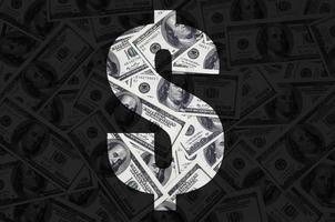 The symbol Dollar on a black background. A pattern from the set of scattered dollar bills as a filling character photo