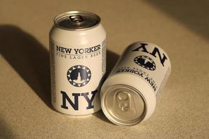 TERNOPIL, UKRAINE - JULY 18, 2022 Two cans of New Yorker fine lager beer with original logo and design on brown retro background photo