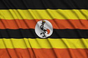 Uganda flag  is depicted on a sports cloth fabric with many folds. Sport team banner photo