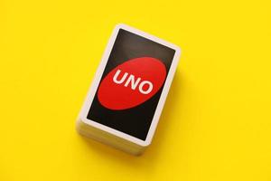 TERNOPIL, UKRAINE - MAY 15, 2022 Many colorful UNO game cards on yellow background. UNO is an American shedding-type card game that is played with a specially printed deck photo