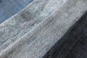 Detailed abstract texture of dark blue denim cloth. Background image of old used denim trousers fabric photo