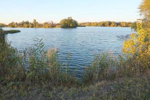 hermoso paisaje otoñal con lago y árboles multicolores. lugar pintoresco con lago y árboles altos foto