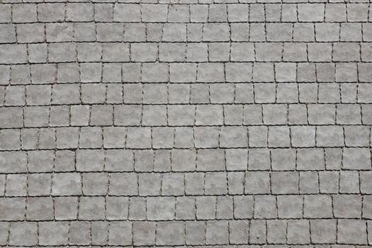 Gray color paving slabs in the pedestrian street sidewalk. Rough cobblestone pattern with many square shaped stones photo