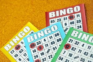 Many colorful bingo boards or playing cards for winning chips. Classic US or canadian five to five bingo cards on bright background photo