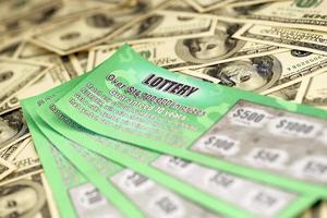 Close up view of green lottery scratch cards and us dollar bills. Many used fake instant lottery tickets with gambling results. Gambling addiction photo